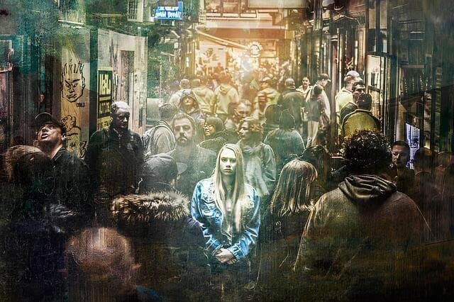 Foto de uma mulher no meio de uma rua lotada de gente. Ela parece estar com ansiedade. A foto ilustra o artigo Explorando os Impulsos do Comportamento Humano escrito pelo psicanalista Homero Mônaco para o site A Sessão de Terapia.