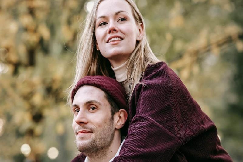 Foto de um casal de namorados no parque. A namorada parece estar de cavalinho no namorado e ambos parecem sorridentes e felizes. A foto ilustra o artigo 5 Melhores Maneiras de Aumentar a sua Confiança nos Relacionamentos escrito pelo psicanalista Homero Monaco para o site Online Psicanalista.