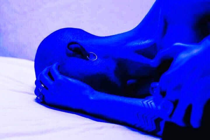 Foto de uma mulher deitada de lado. A foto é toda azulada e dá a sensação que ela não tem forças para levantar da cama por causa da depressão. A foto ilustra o artigo 25 Sinais e Sintomas da Depressão que você deve ficar atento escrito pelo psicanalista Homero Mônaco para o site Online Psicanalista.