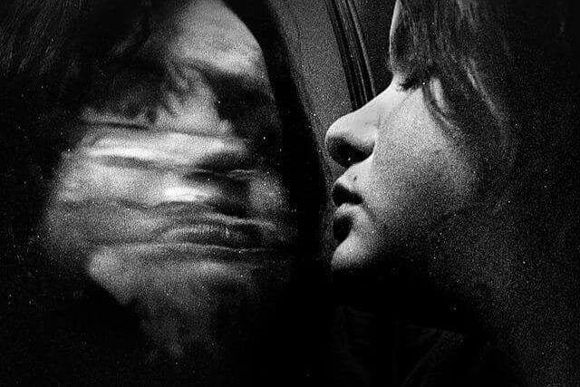 Foto do rosto de uma mulher se olhando no espelho. O reflexo de seu rosto parece desconfigurado. A foto ilustra o artigo O que são Transtornos de Personalidade? Quais são os tipos? Quais são os sintomas? Como tratá-los? escrito pelo psicanalista Homero Mônaco para o site Online Psicanalista.