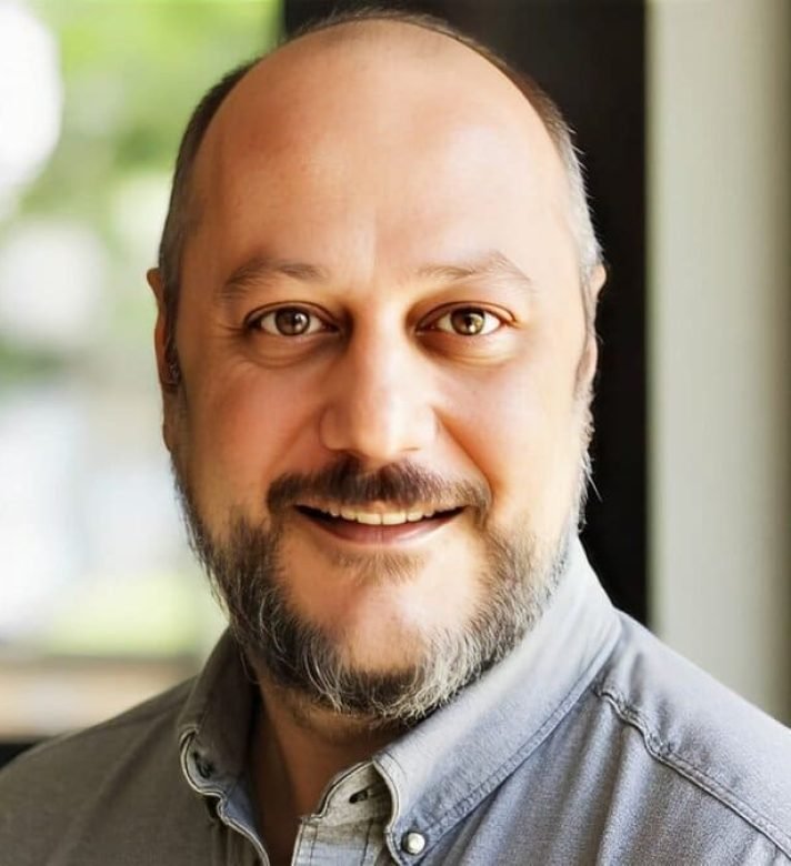 Foto de homem careca, olhos castanhos claros, de barba escura. A foto é do Psicanalista Homero Mônaco, que é o psicanalista que escreve para o blog do Site A Sessão de Terapia e que atende também como psicanalista online.